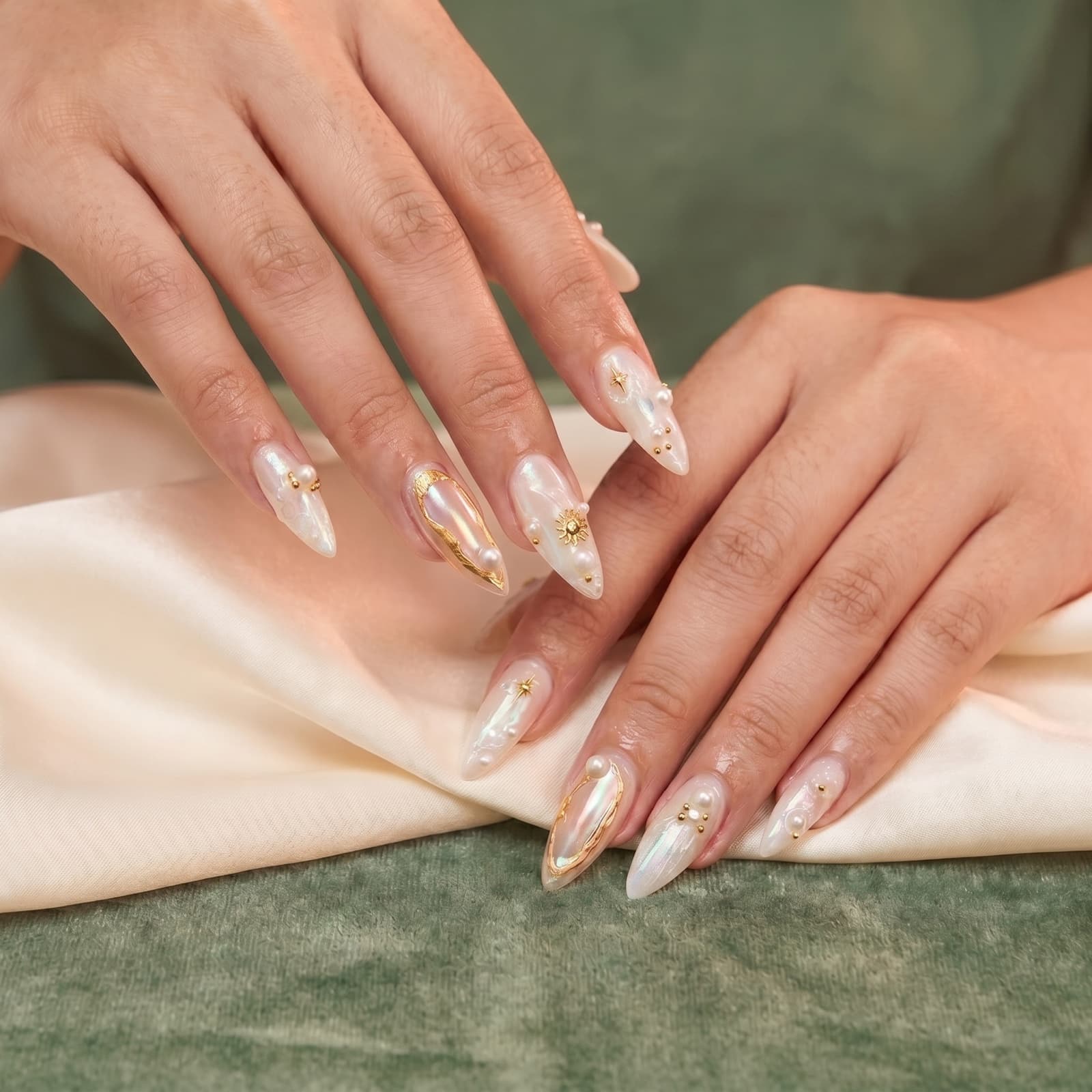 Aura-chrome nails with gold foil and pearl charms